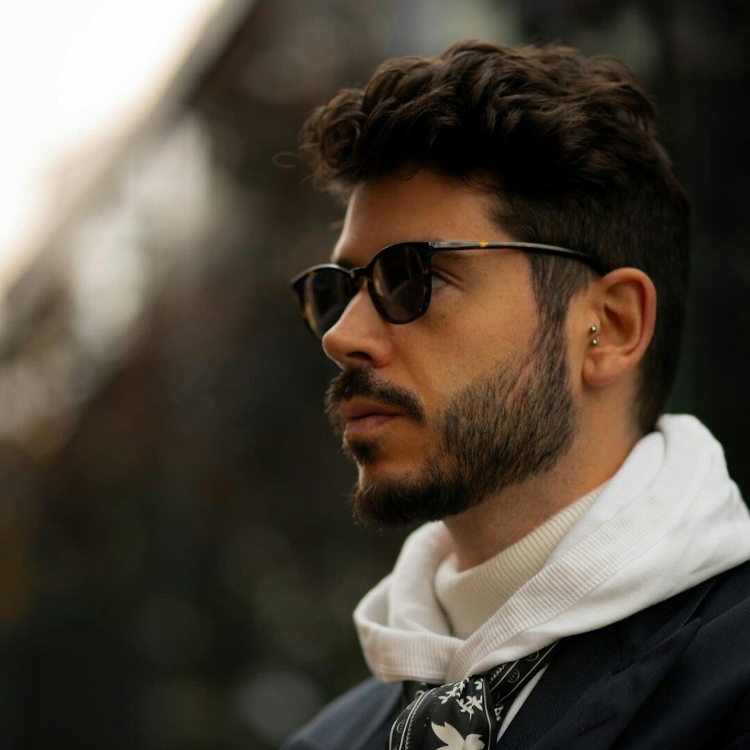 Candid photo of a celebrity man walking in sunglasses and coat